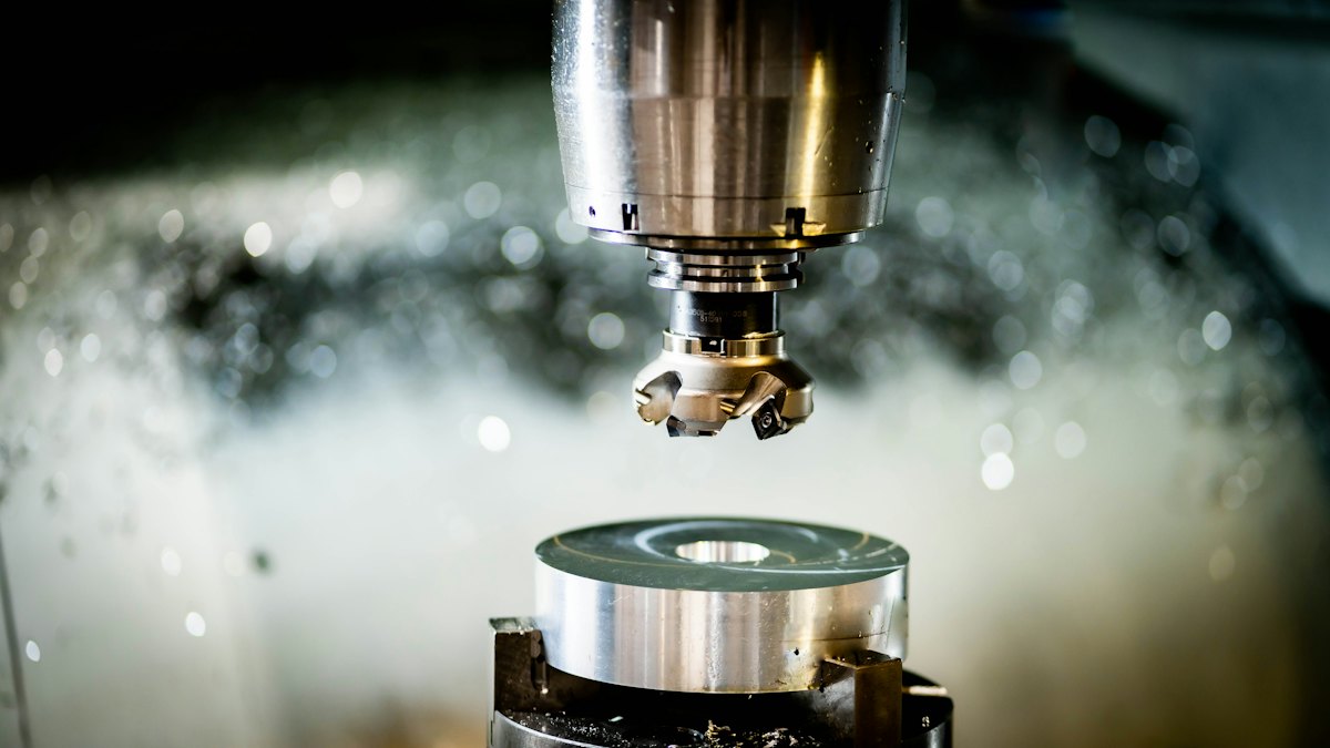 Milling head of a CNC machine above a metal workpiece